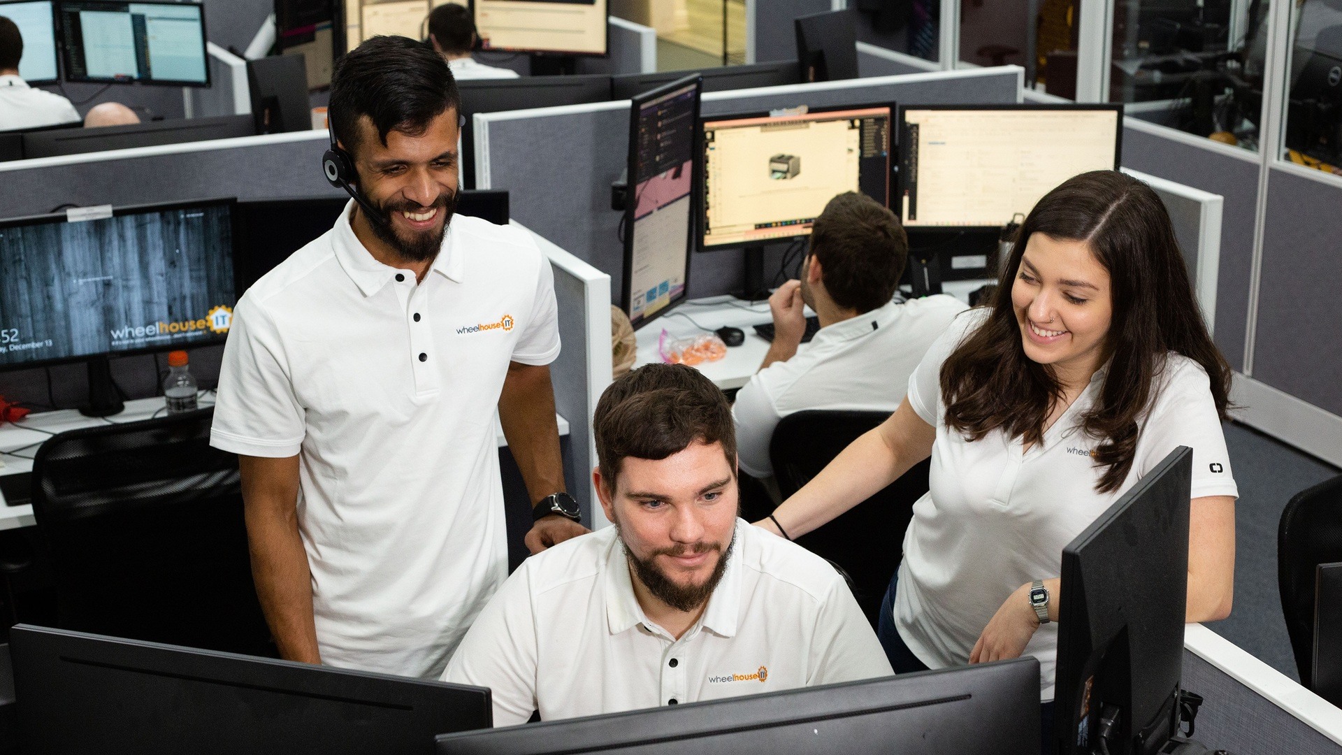 two men and a woman working in an office