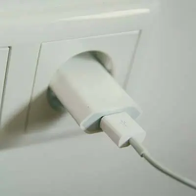 Stylish White Usb Charger Plugged Into Modern Outlet For Sleek Device Charging. Wireless Charging. stylish white usb charger plugged into modern outlet for sleek device charging. wireless charging.