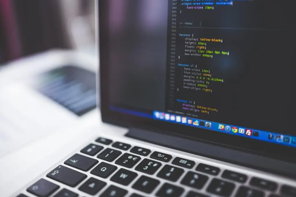 Sleek Laptop Displaying Colorful Lines Of Code In Modern Workspace For Programming Tasks. Malicious Software. sleek laptop displaying colorful lines of code in modern workspace for programming tasks. malicious software.