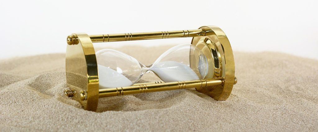 timeless brass hourglass on sand, symbolizing passage of time and lifes beauty. vendor management.