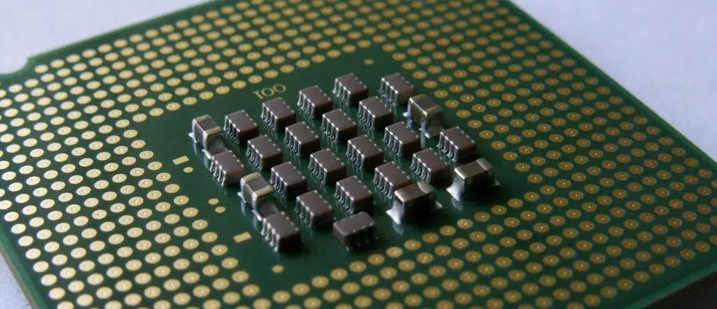 inside look at advanced microprocessor design with intricate metallic pins on green pcb.