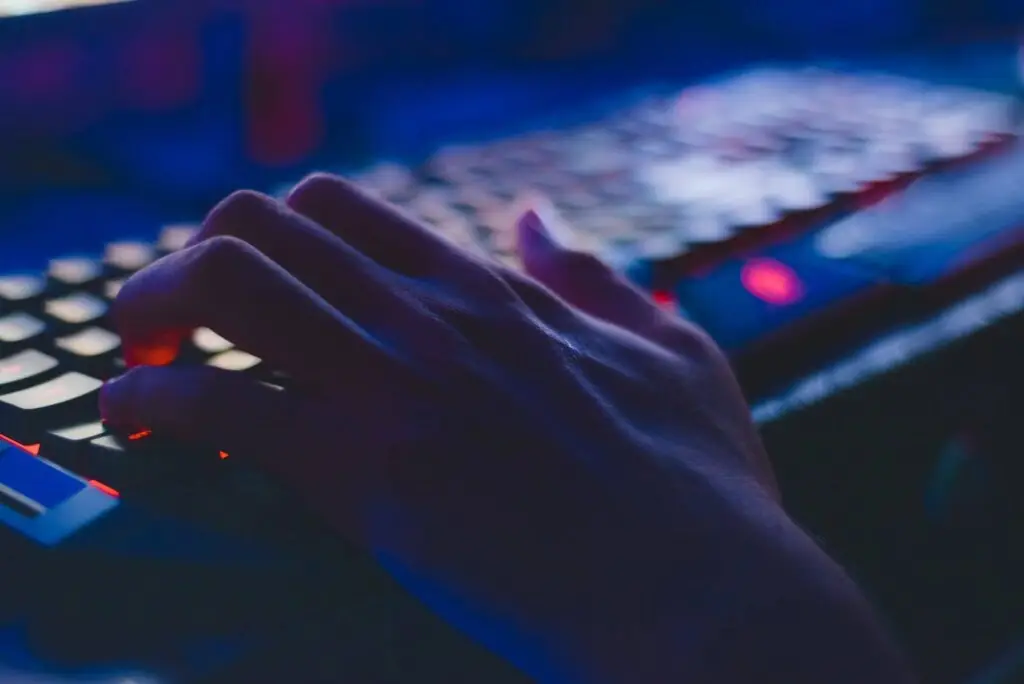 Hand On Backlit Gaming Keyboard In Moody Nighttime Setting, Ready For Action. Wireless Security. hand on backlit gaming keyboard in moody nighttime setting, ready for action. wireless security.