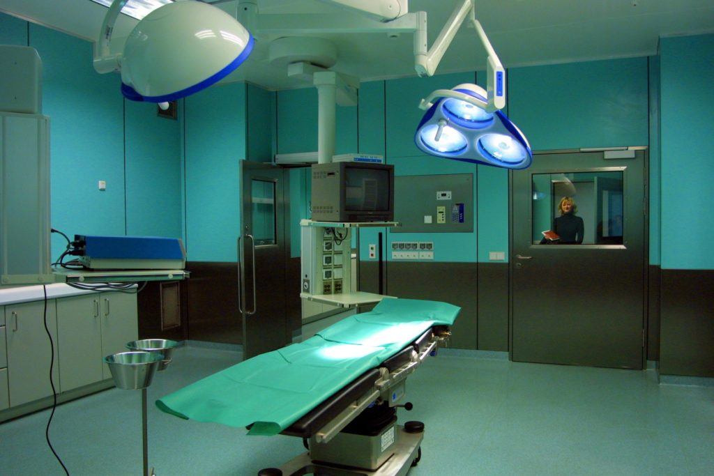 modern surgical room with bright lights, green table, and advanced equipment for procedures. medical.