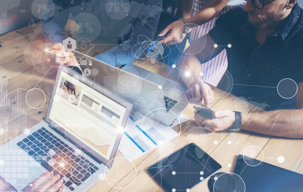 tech-driven teamwork in modern workspace with laptops, smartphones, and digital collaboration. business intelligence.