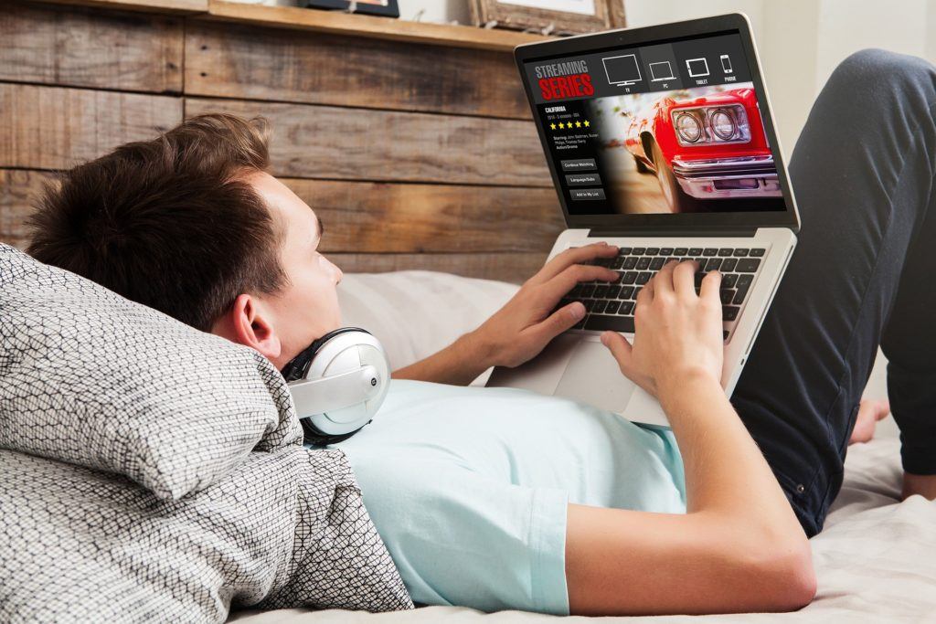 creative video editing in cozy bedroom with headphones, laptop, and rustic decor. sextortion.