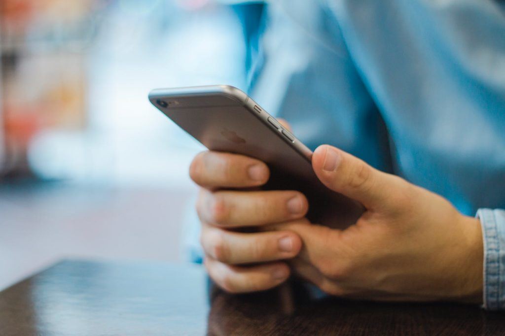 person using smartphone in cozy cafe, captured in modern tech moment. smart devices.
