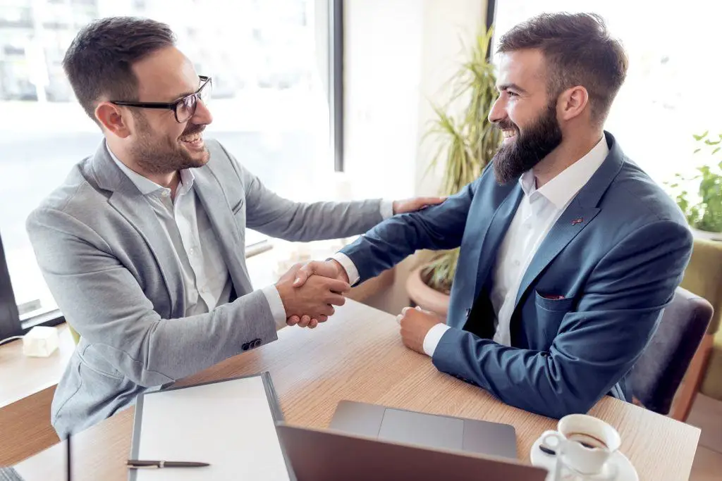 Successful Business Handshake In Bright Office Space Signifies Partnership And Collaboration. Co-Managed It. successful business handshake in bright office space signifies partnership and collaboration. co-managed it.