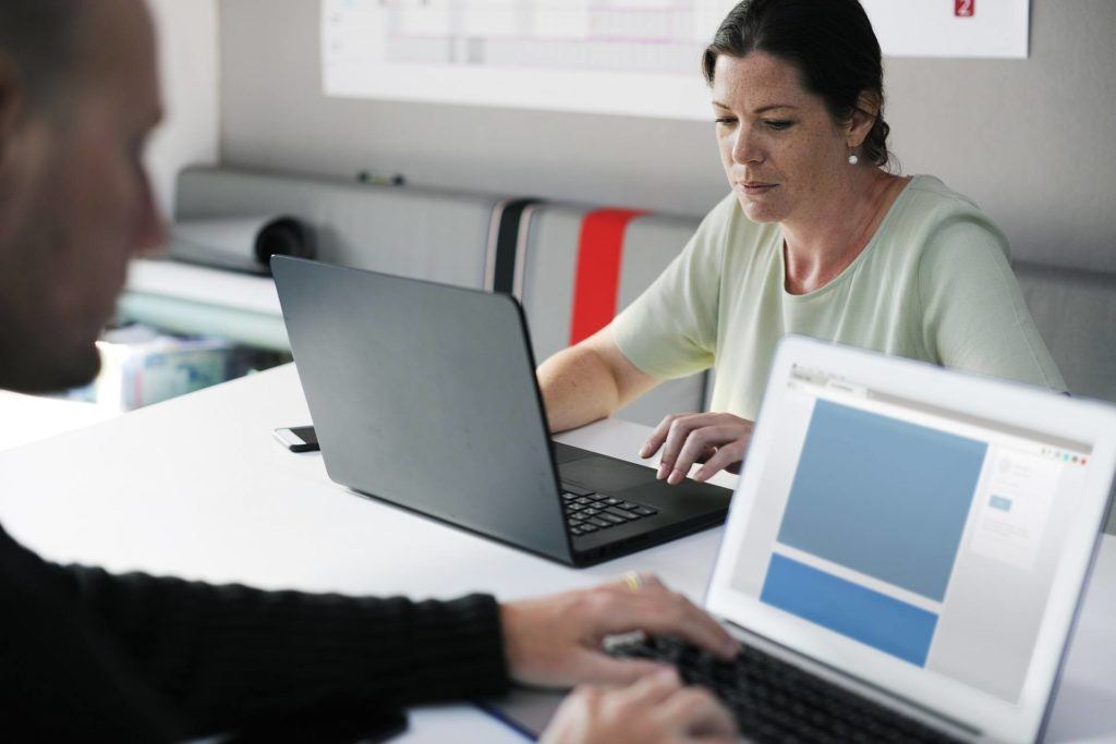 focused professionals collaborating on laptops in a modern office for productivity.