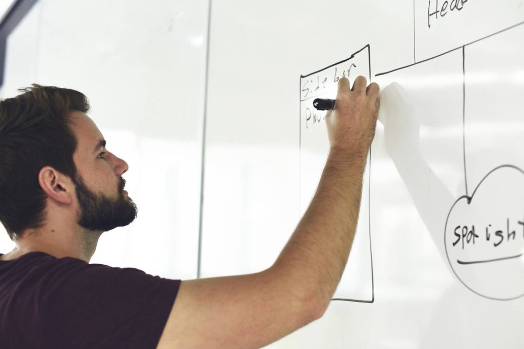 creative teamwork: man brainstorming on whiteboard in modern office for innovative ideas. better productivity.