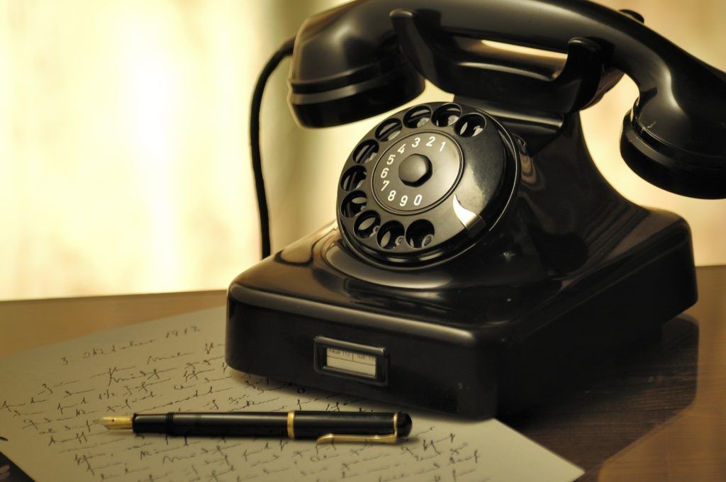 vintage telephone and pen evoke nostalgia and intimate communication in serene setting.