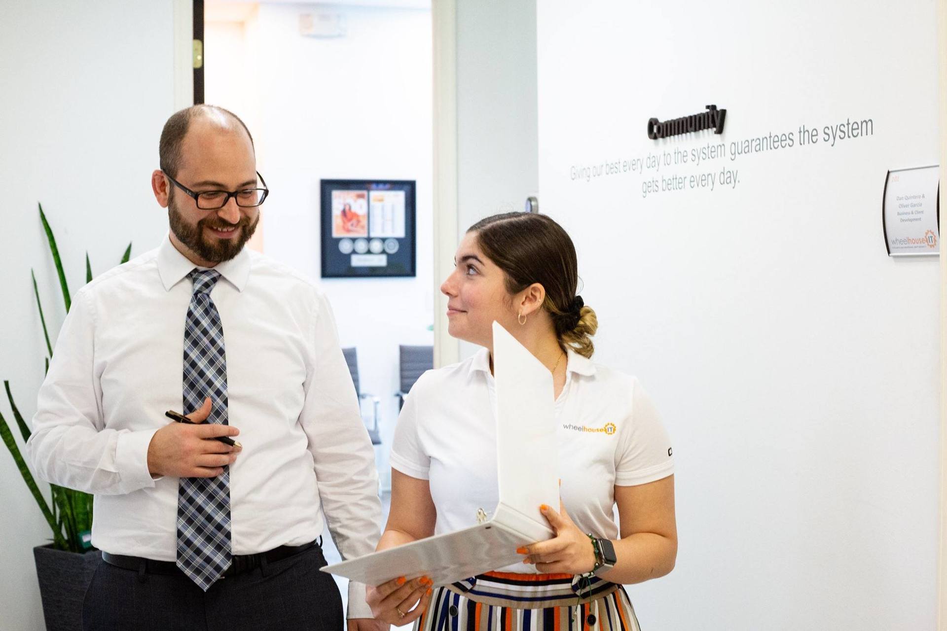 a man and woman standing next to each other in an office