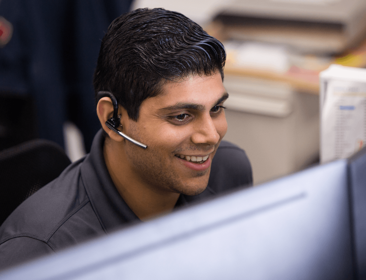 a man wearing a headset and smiling at the camera