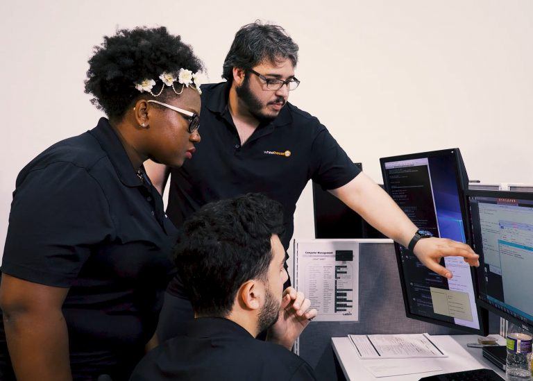 three people looking at a computer screen together