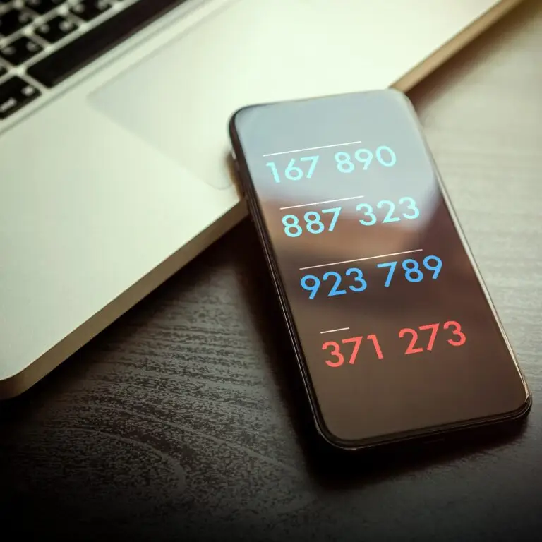 a cell phone sitting on top of a table next to a laptop