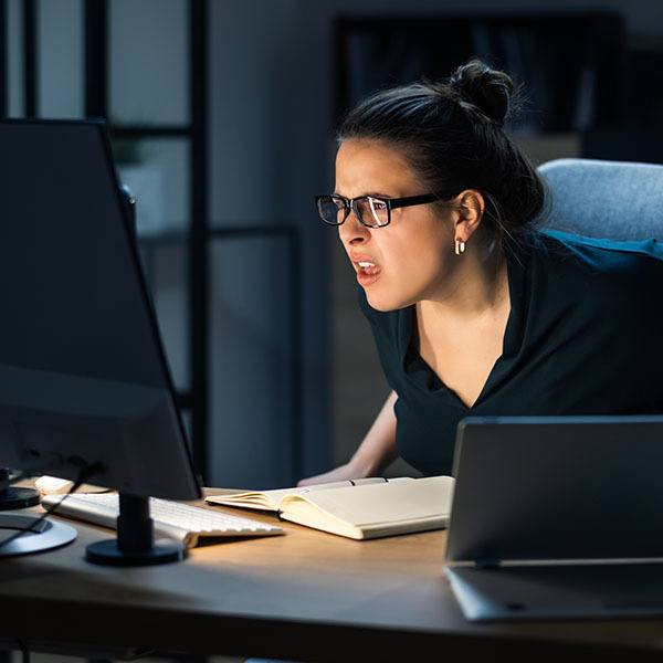 a woman in glasses looking at a computer screen