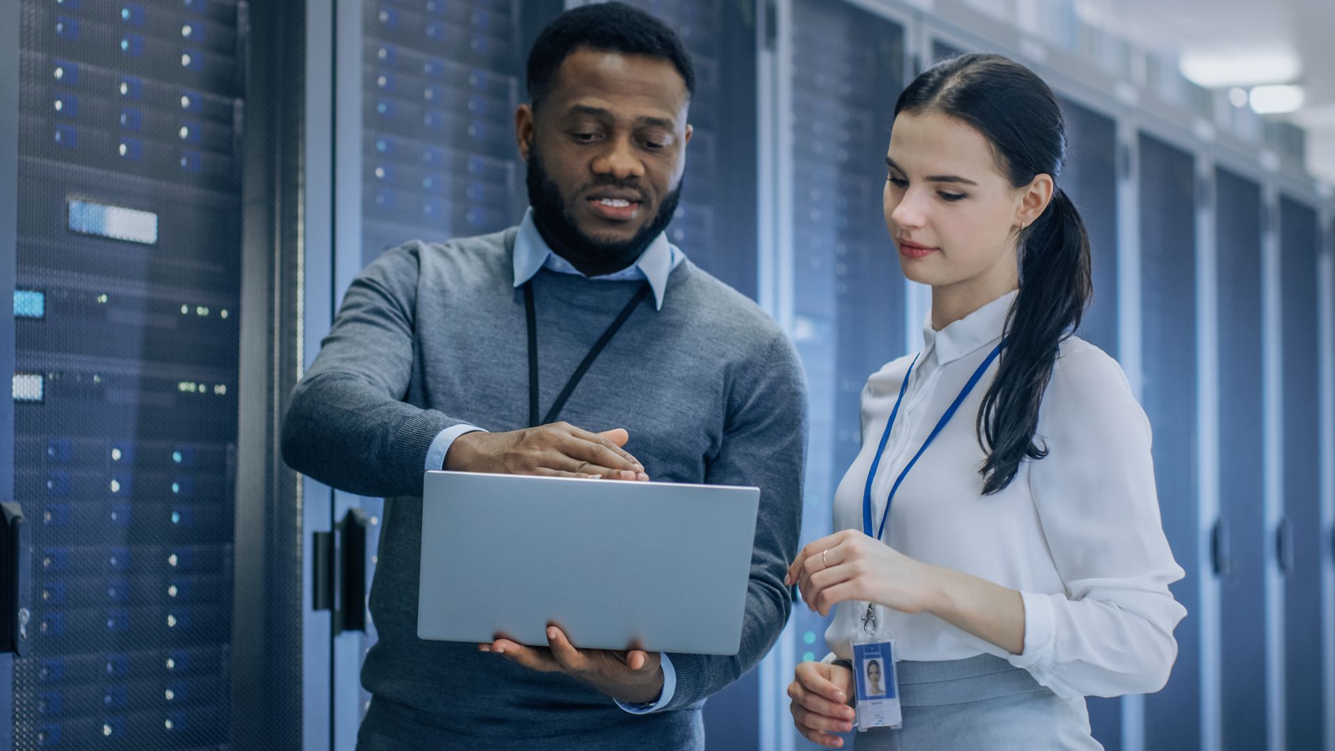 a man and woman standing in front of servers