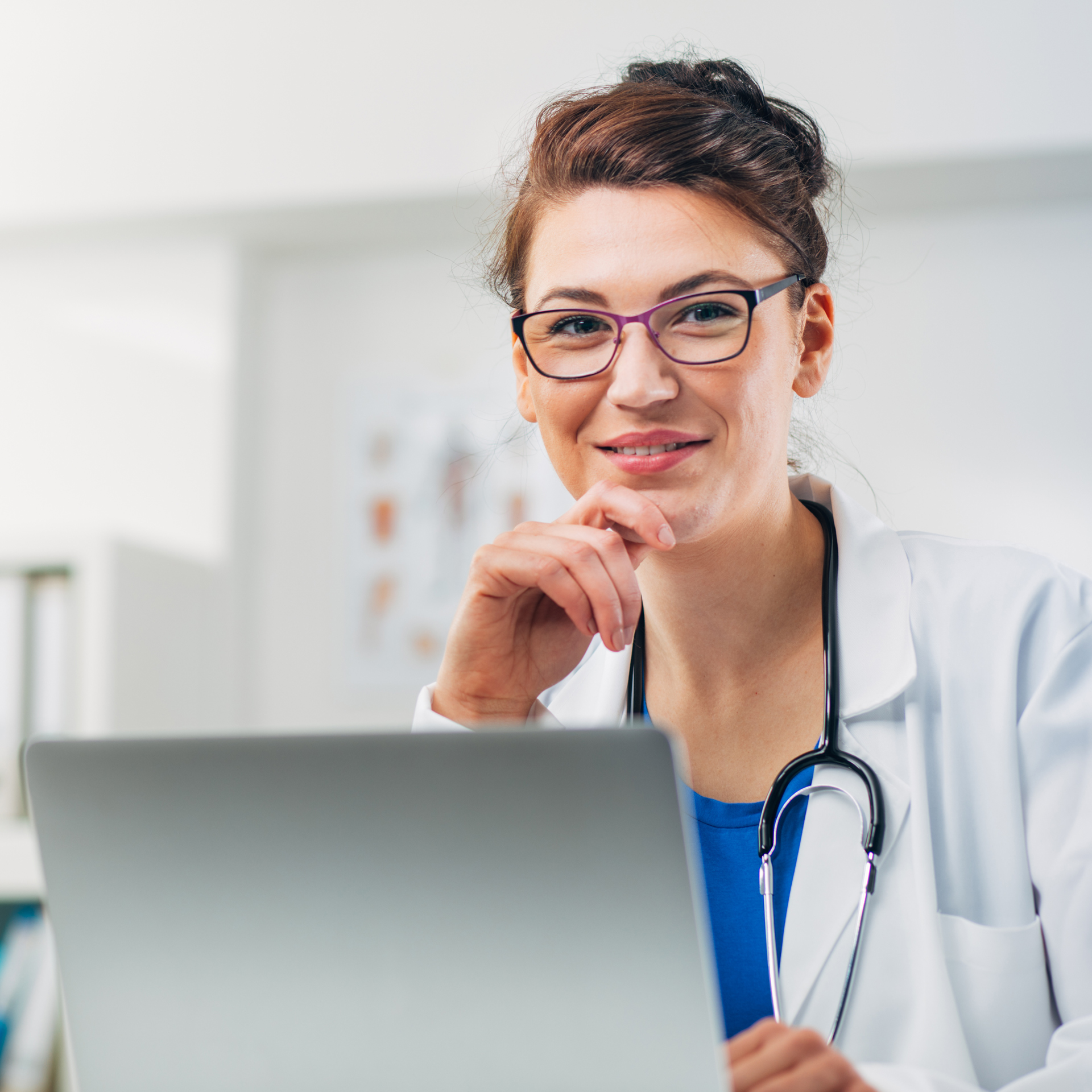 a female doctor is looking at her laptop