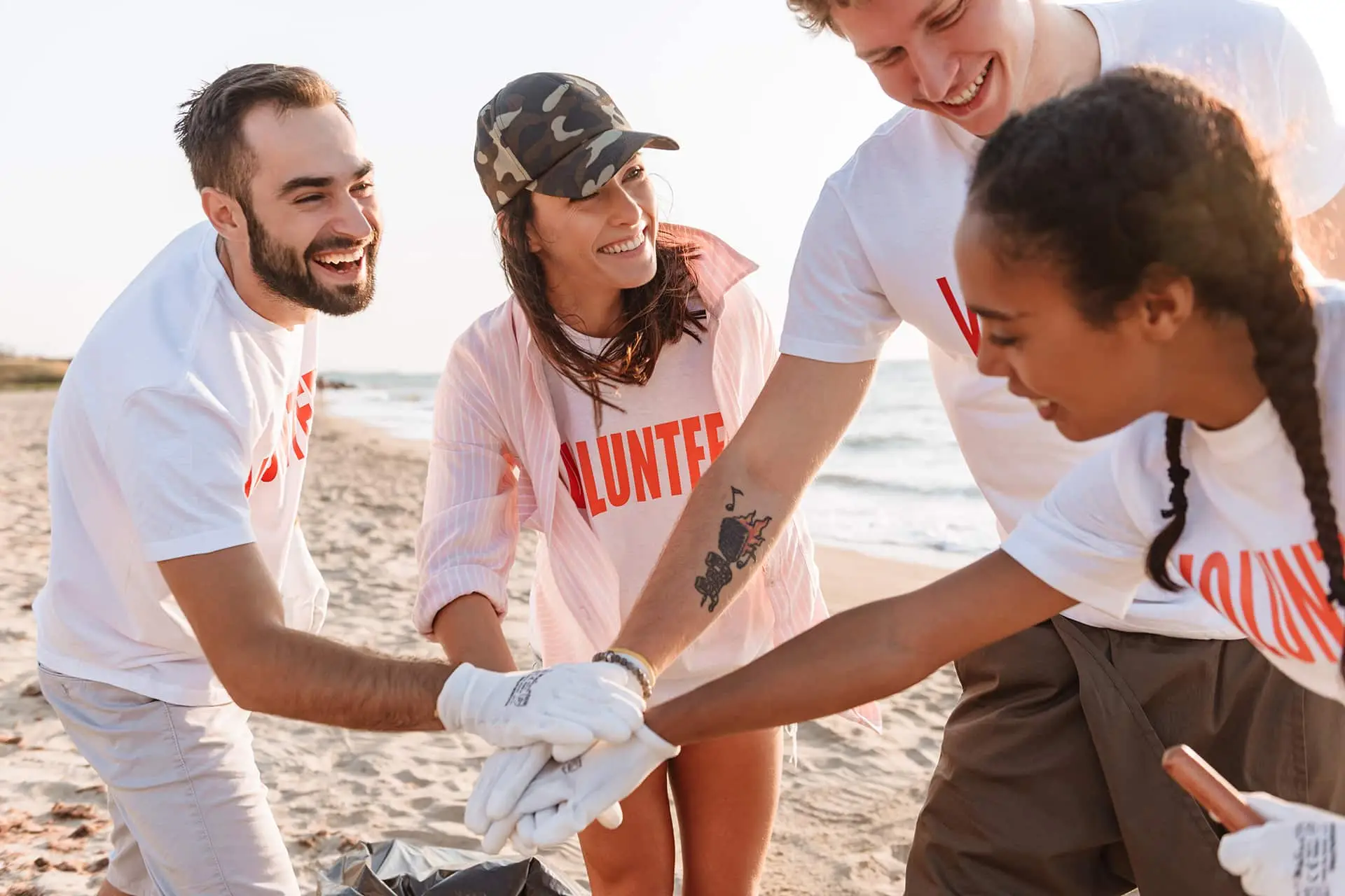 a group of people standing on top of a sandy beach