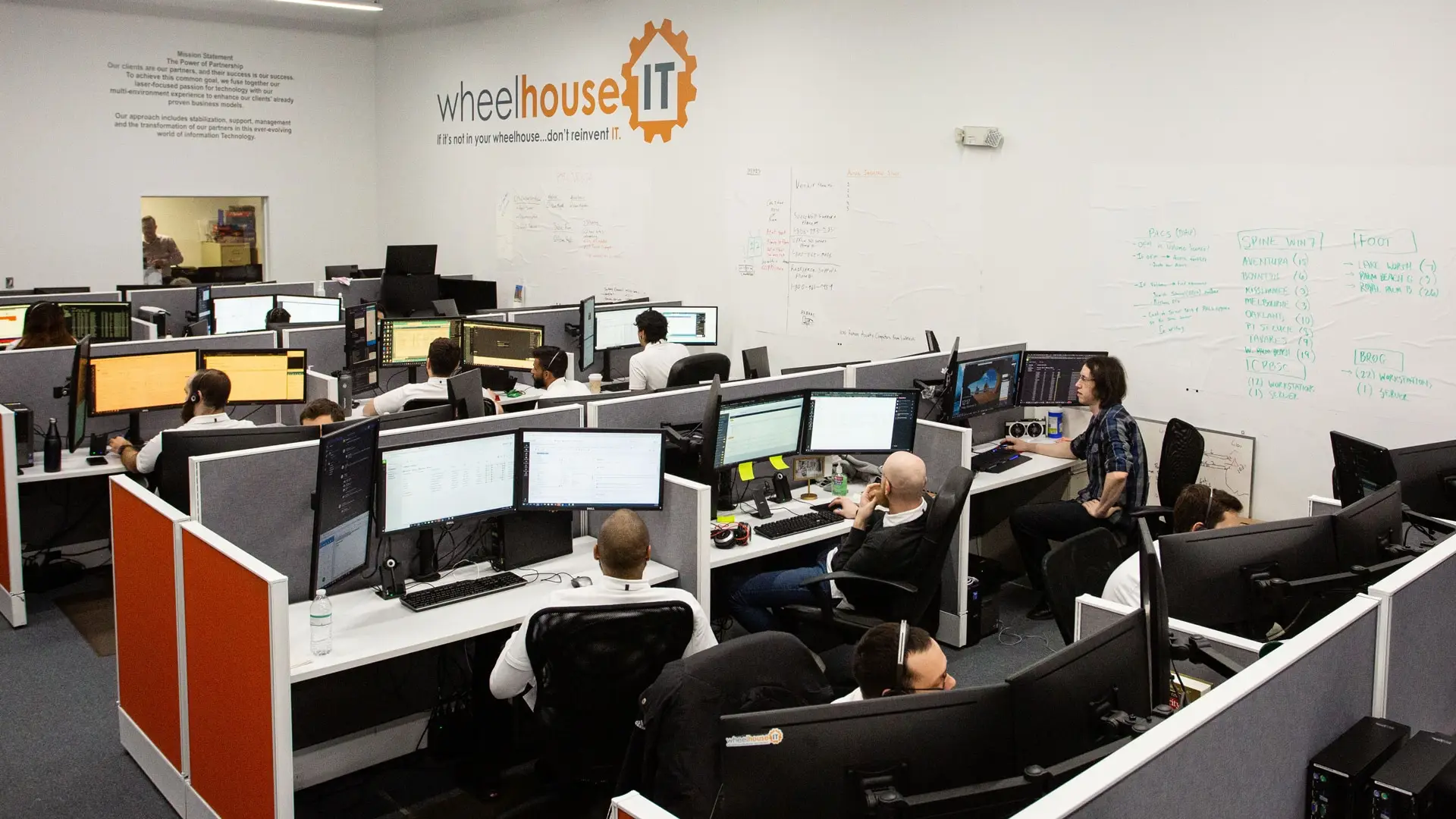 a group of people sitting at desks working on computers