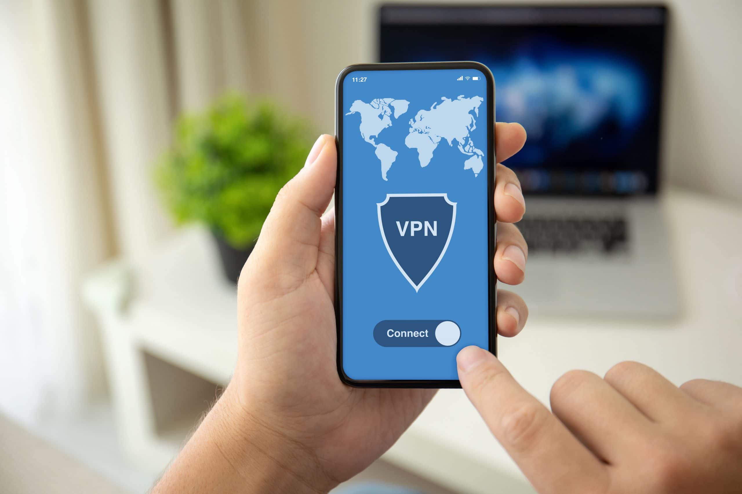 a person holding up a phone with the word vpn on it