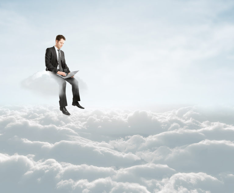 Man in suit typing on cloud, symbolizing balance between work and dream in digital era. Migrating to the Cloud.