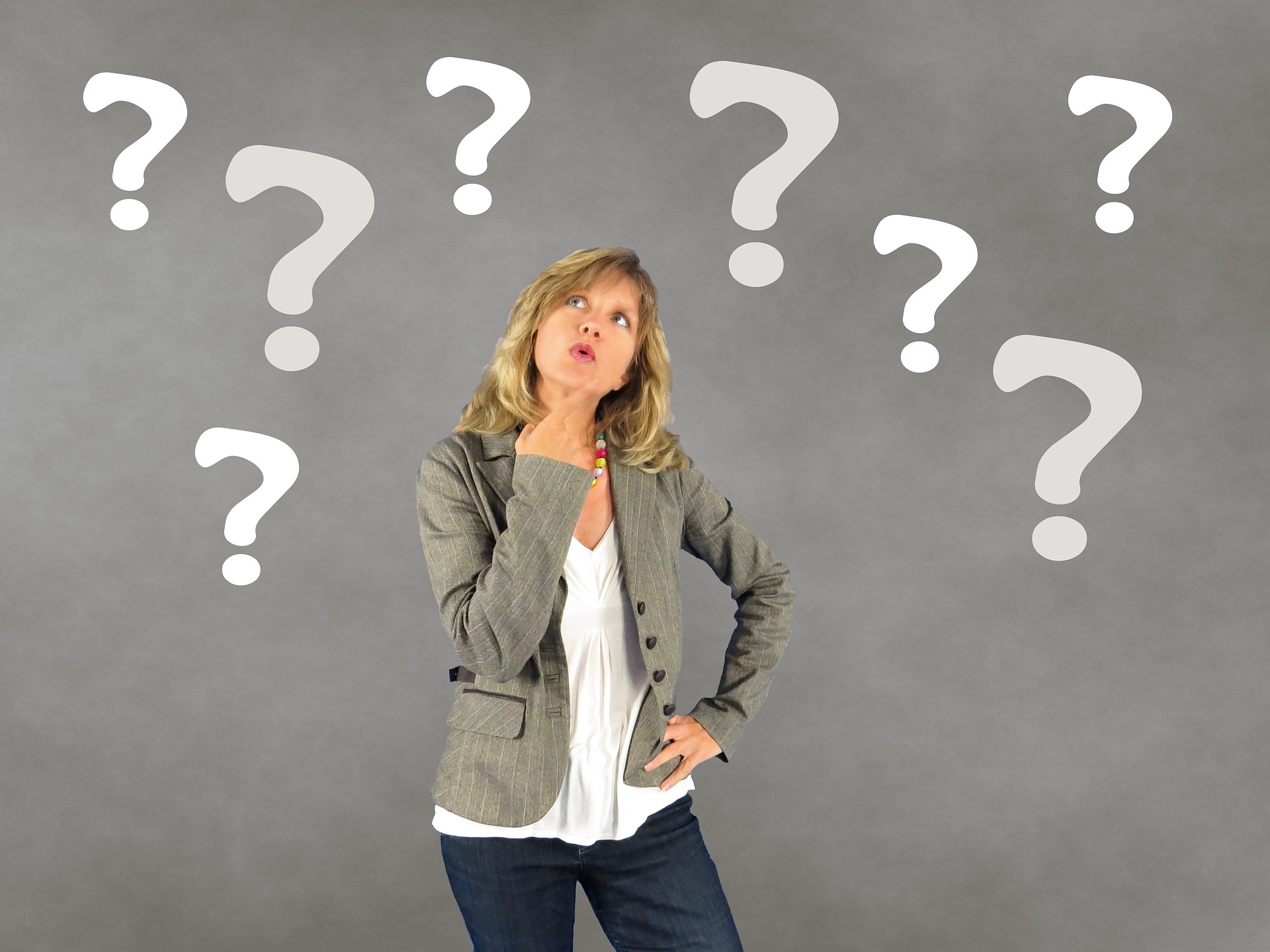 a woman is standing in front of question marks