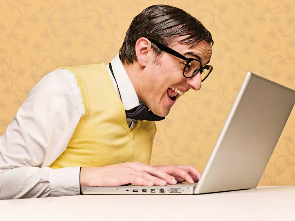 excited man at laptop, exuding joy and curiosity in tech discovery. it stereotypes.