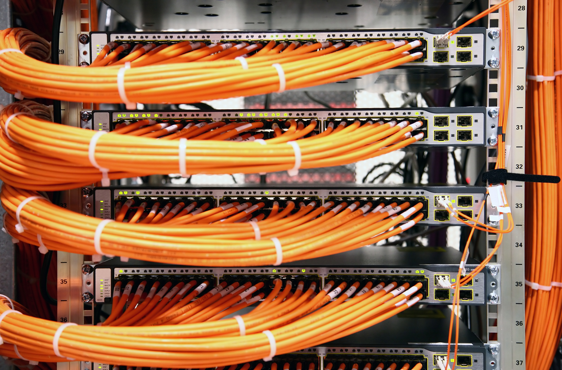 several orange wires are connected to the back of a server