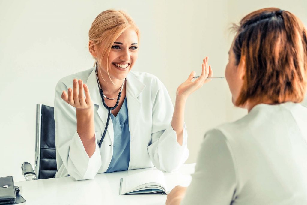 a woman talking to a doctor in an office