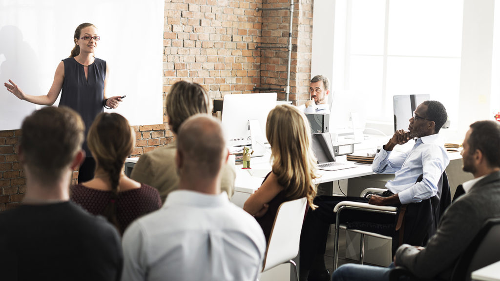 collaborative office training session with diverse group and confident female speaker.