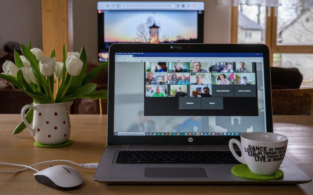 sunset-themed home office with video call, tulips, coffee mug, and motivational message.