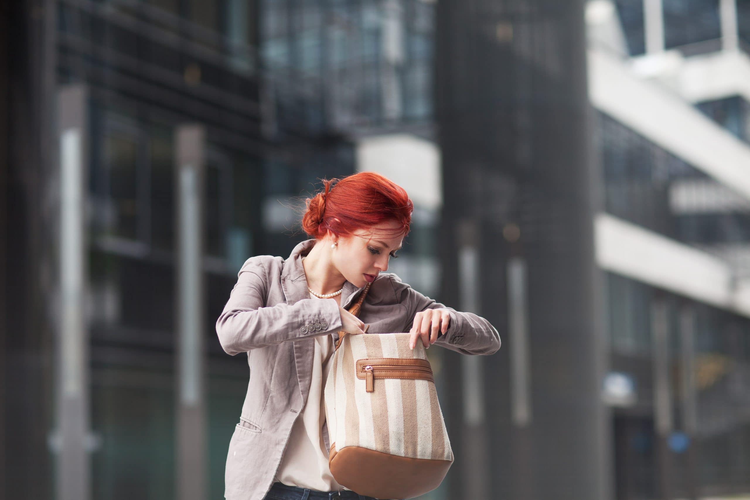 a woman with red hair carrying a purse