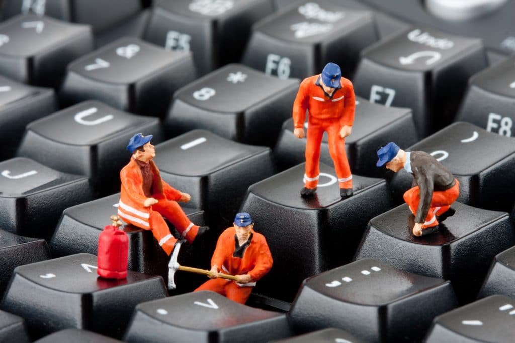 whimsical construction workers performing tasks on computer keyboard in imaginative scene.