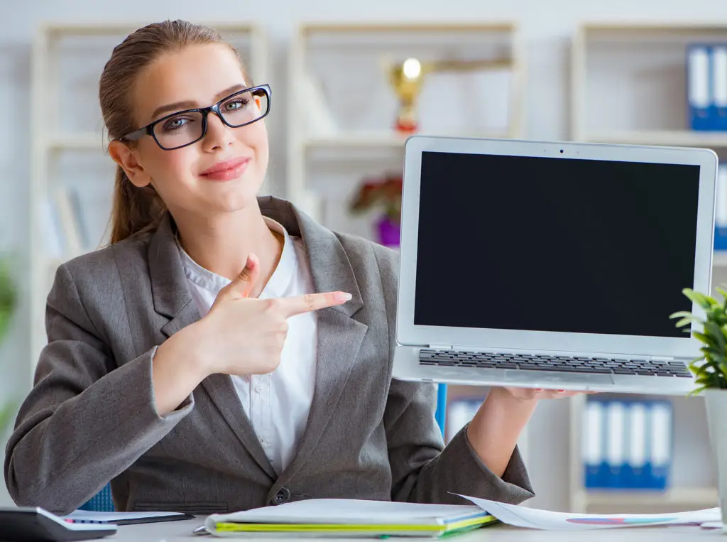 modern office professional holding laptop, ready to present in stylish workspace.
