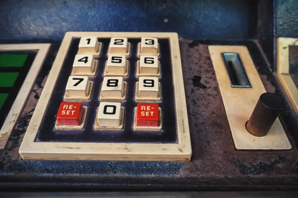 retro keypad with worn numbers and red reset buttons, evoking nostalgia for vintage devices. technologies.