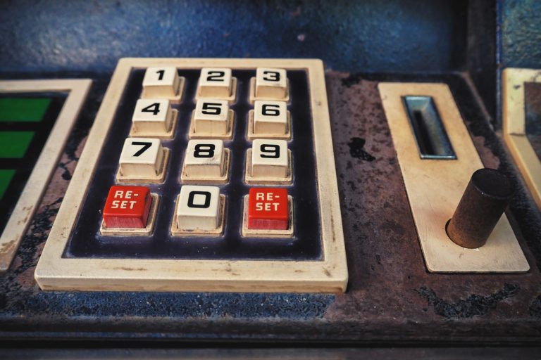 Retro keypad with worn numbers and red reset buttons, evoking nostalgia for vintage devices. technologies.