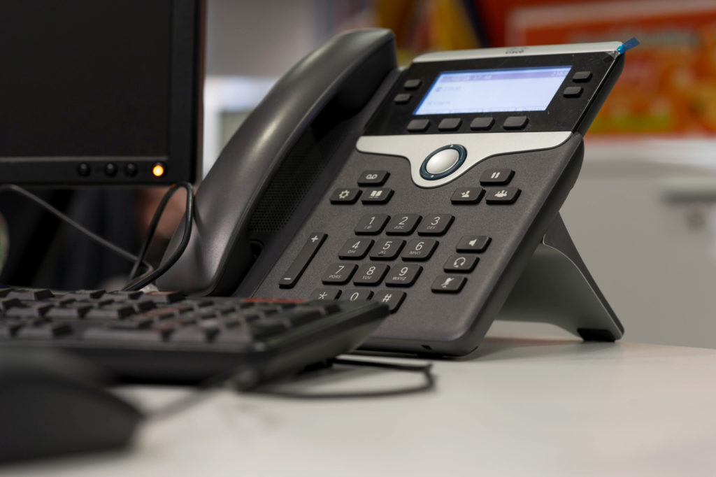 modern office desk with ip phone and computer for efficient communication.