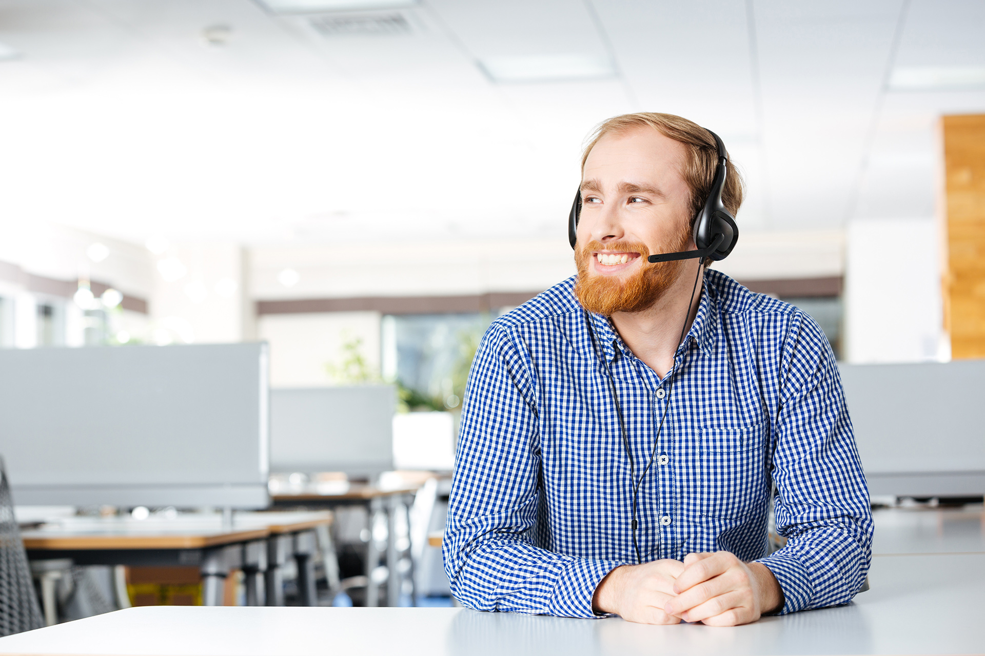a man wearing a headset sitting at a desk