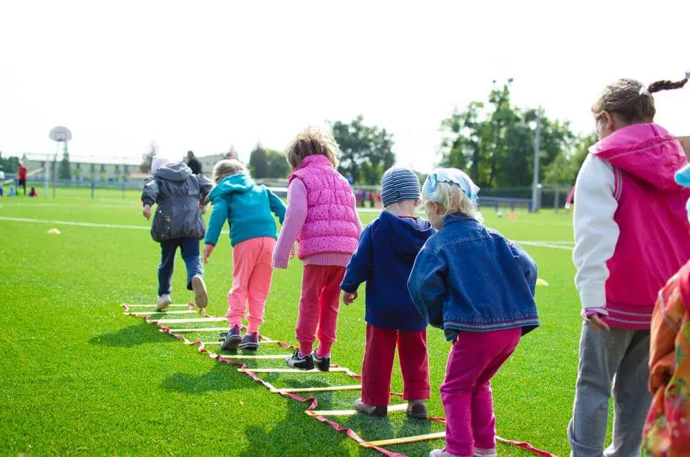 children enjoying outdoor agility training in vibrant setting, fostering teamwork and coordination skills.