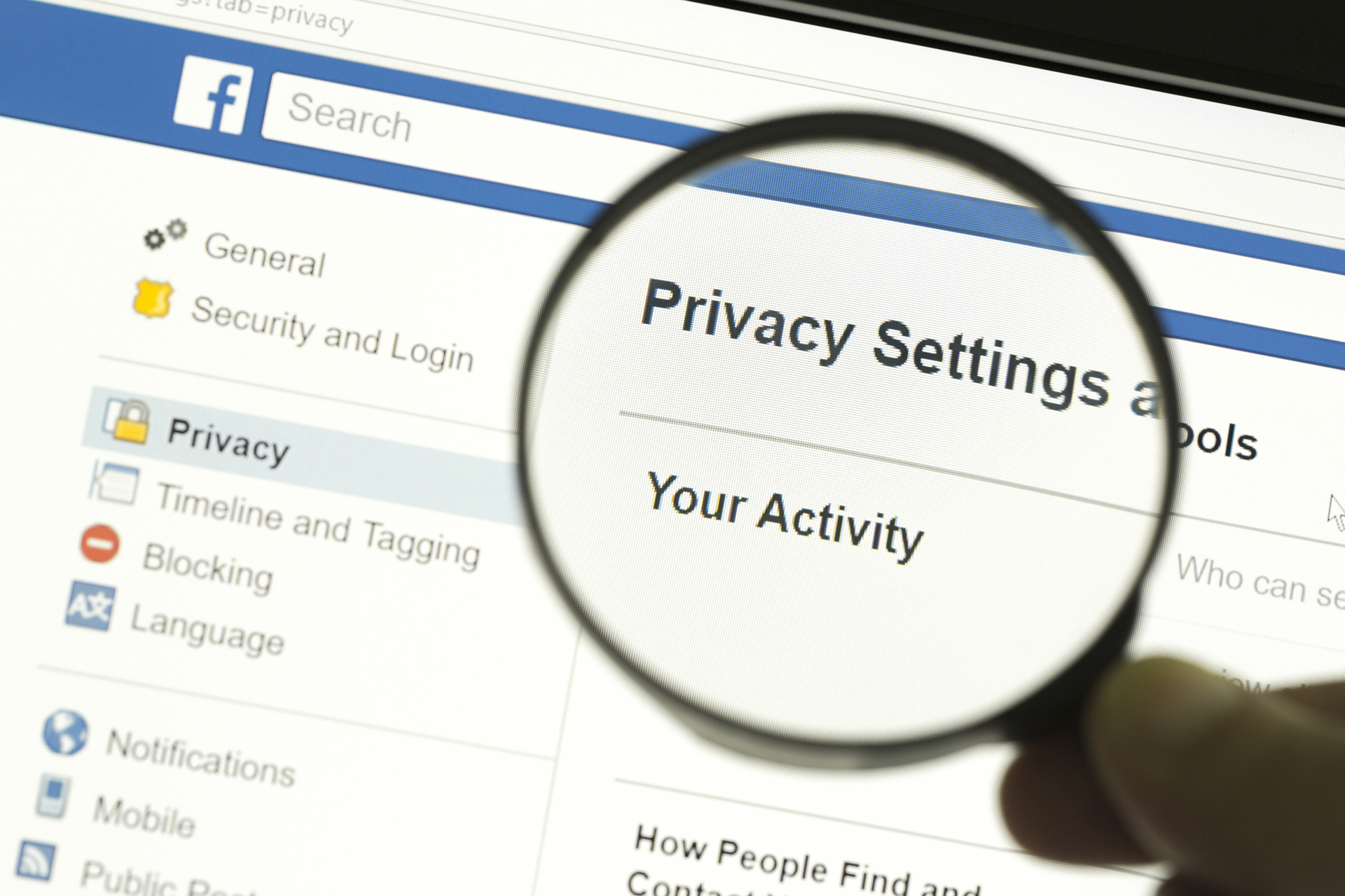 a person holding a magnifying glass looking at privacy settings