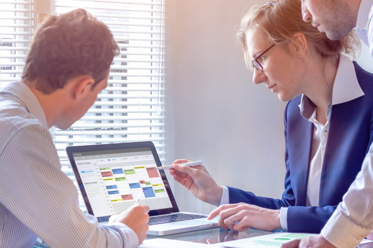 Intense teamwork discussion in modern office using digital calendar. Prioritize Productivity.