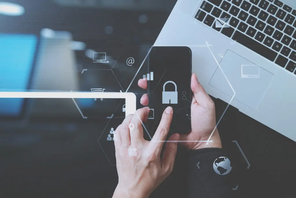 Modern Workspace: Smartphone And Laptop Interaction With Digital Security And Connectivity. modern workspace: smartphone and laptop interaction with digital security and connectivity.