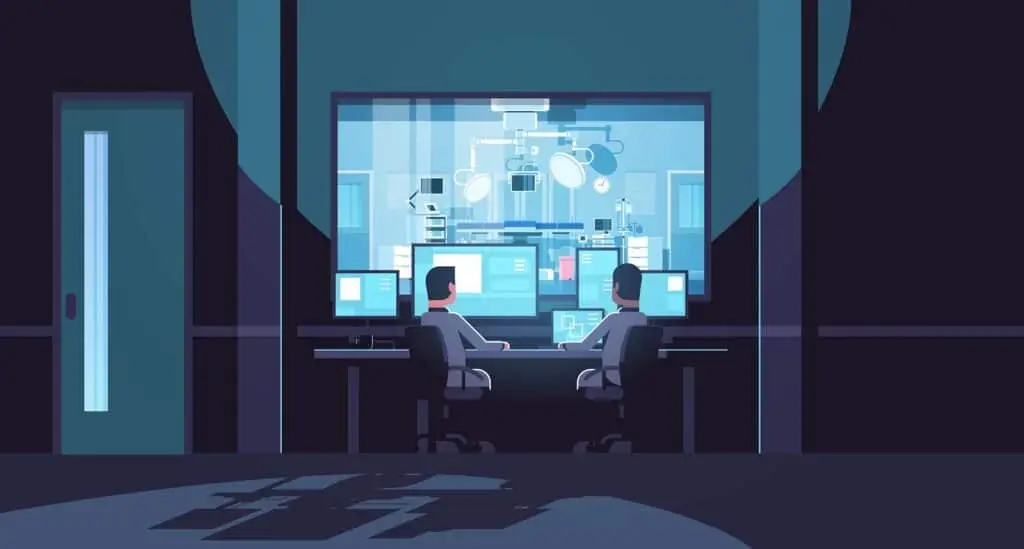 two people sitting at a desk in front of computers