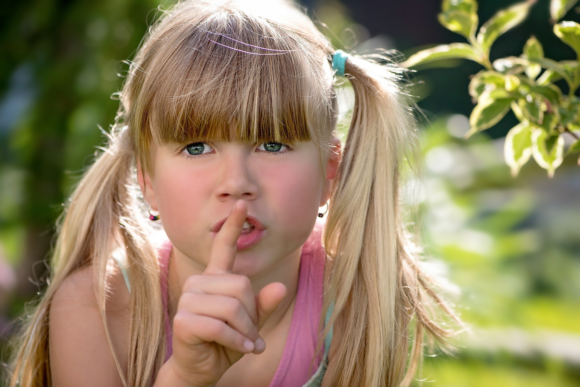 a little girl making a hush with her finger