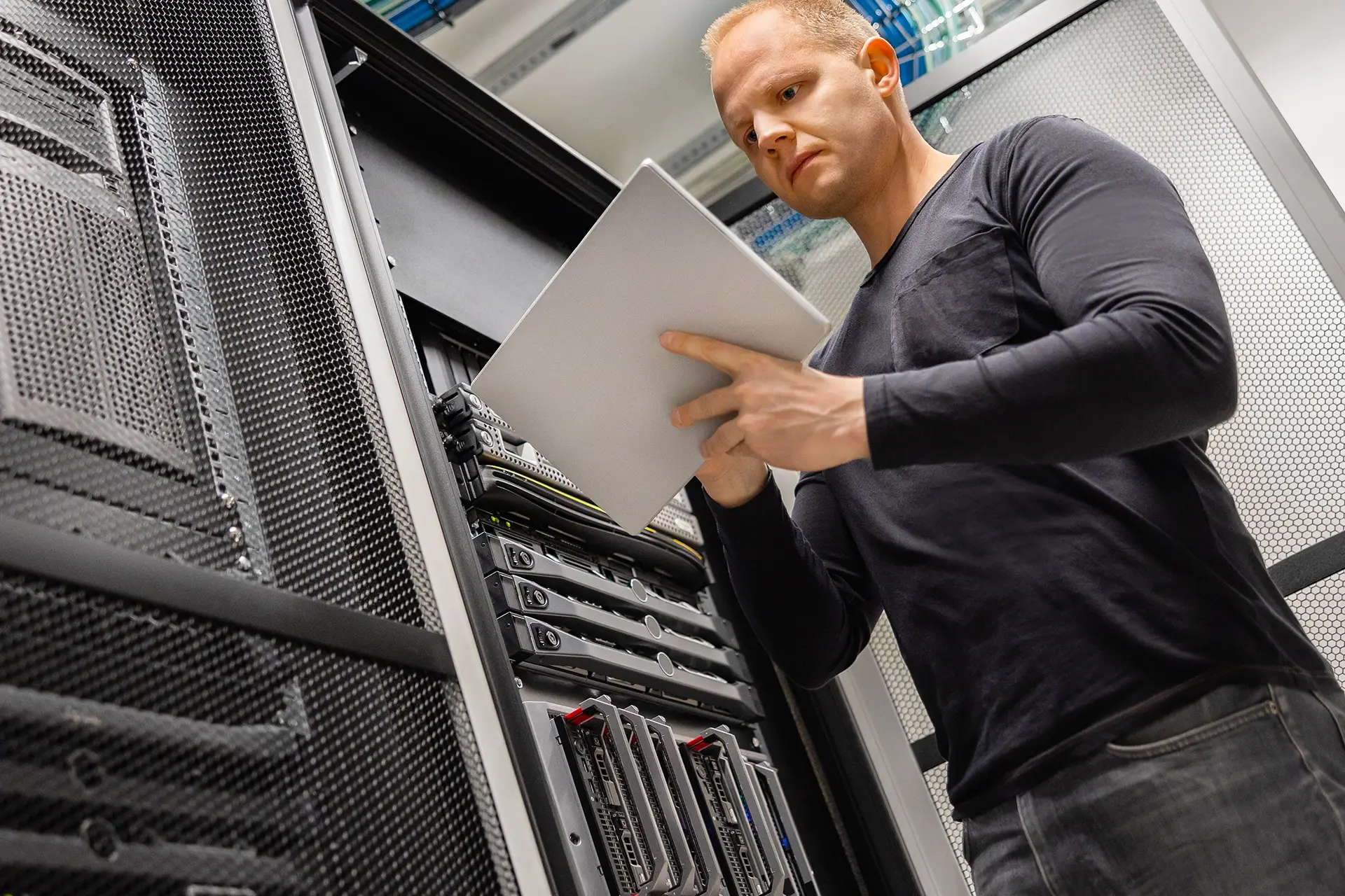 a man standing in front of a server holding a piece of paper