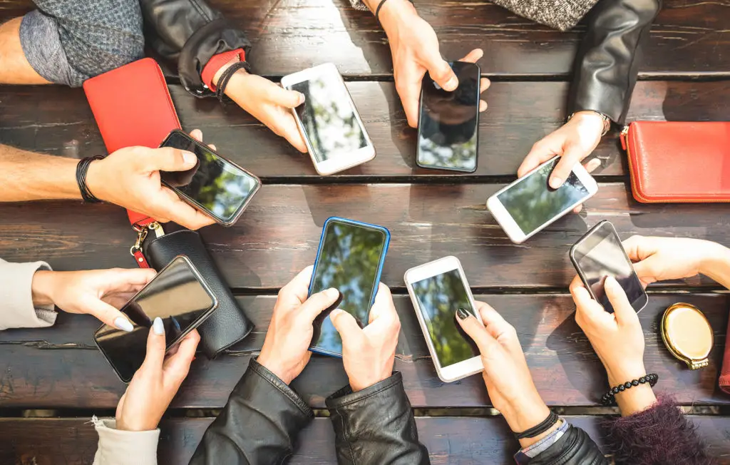 diverse hands with smartphones in a modern social circle.