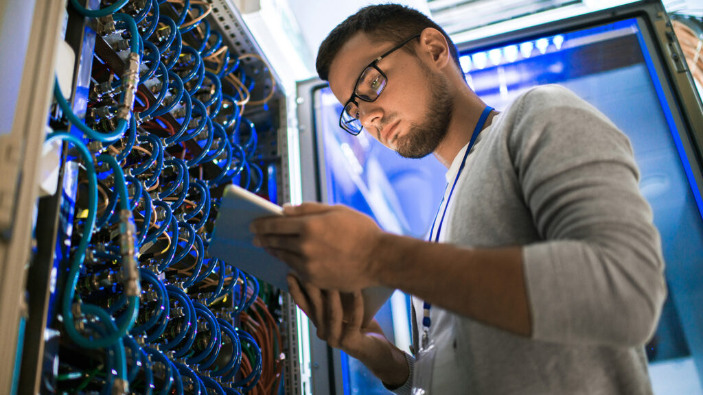 a man in glasses is looking at something on his tablet