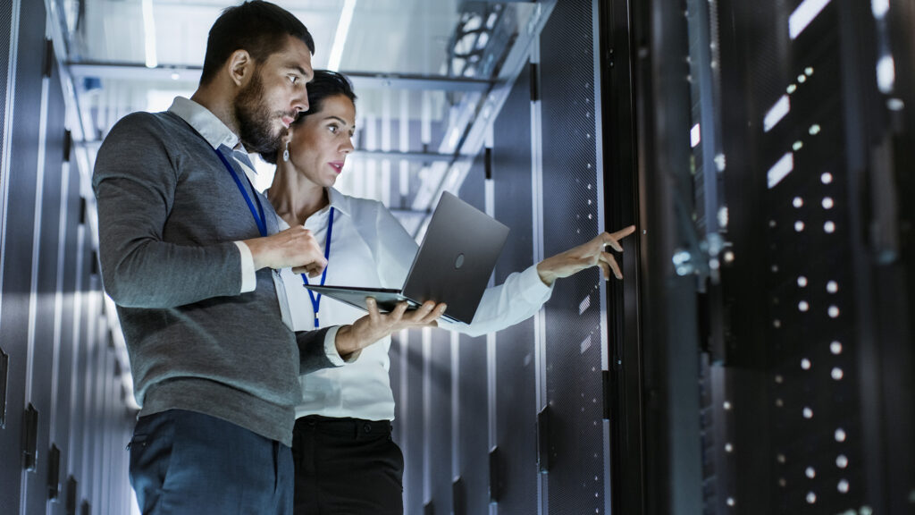 a man and woman standing in front of a server