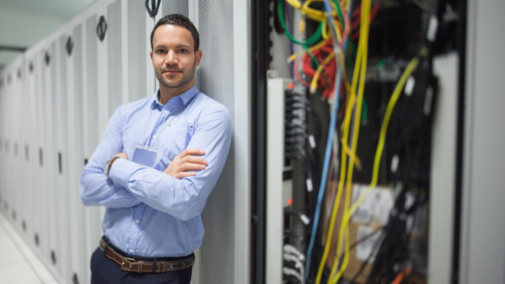 a man standing in front of a server with his arms crossed