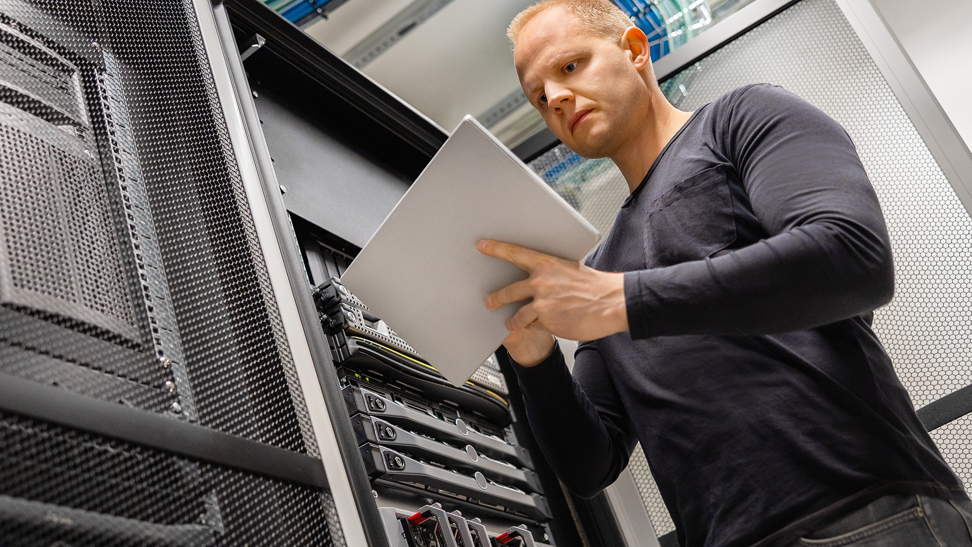 a man standing in front of a server holding a piece of paper